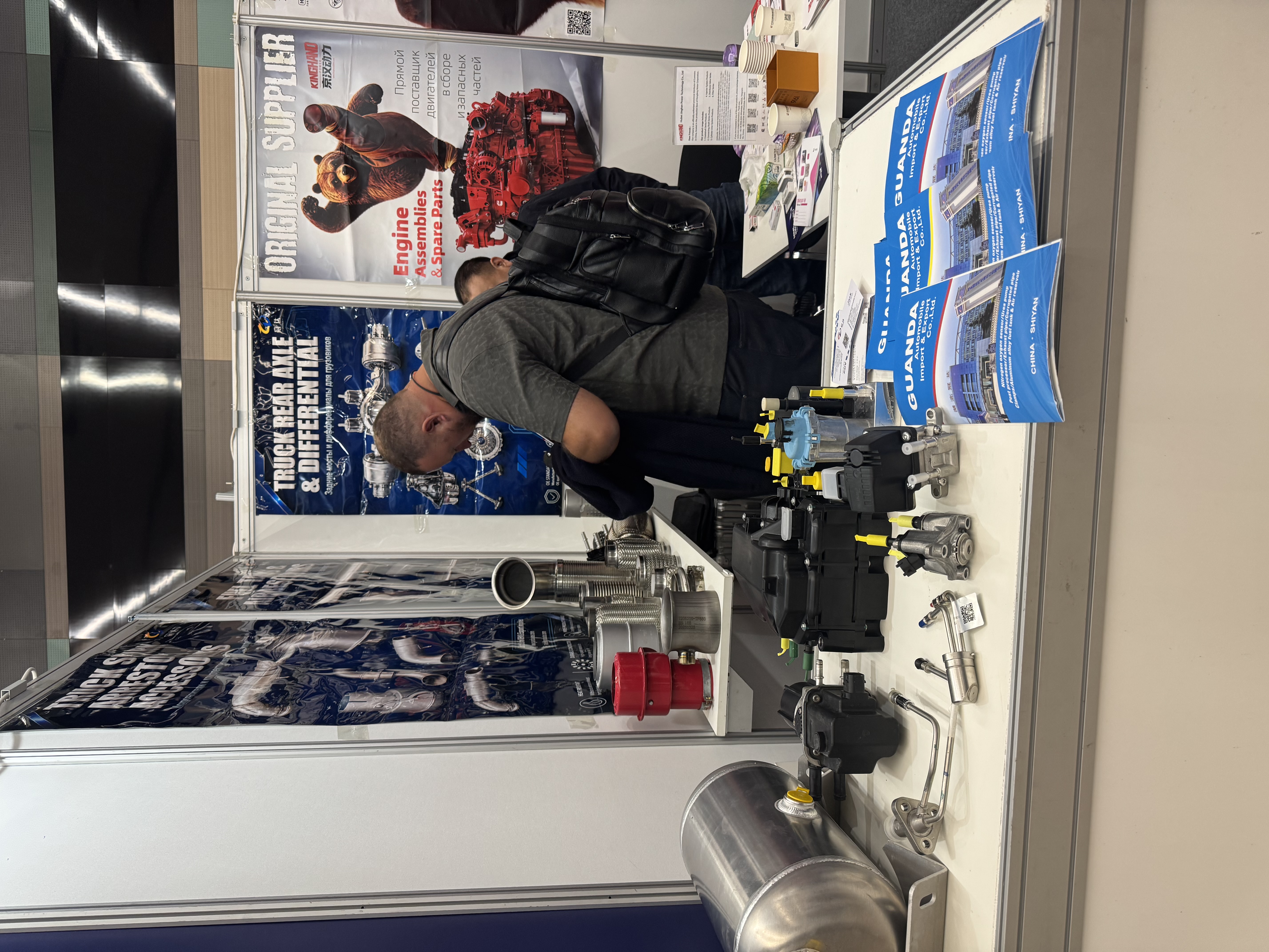 Hubei Guanda Automobile booth counter at MIMS 2026 Saint Petersburg showing SCR urea pumps and aluminum air reservoir